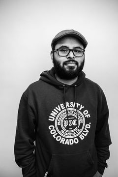 A duotoned black-and-white portrait of Bryan Coreas.