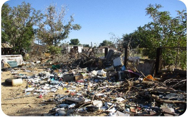 Image of rural property with discarded furniture, debris and trash in foreground