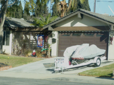 Photo 13: A boat trailer is parked within in the driveway.
