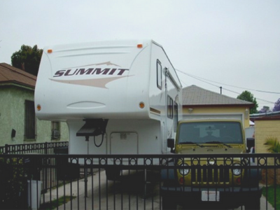 Photo 16: A fifth wheel camper trailer is parked within the driveway.