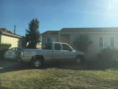 Photo 9: A pickup truck is parked on the lawn within the required front yard area of a residential property.